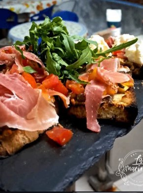 Focaccia topped with prosciutto, tomato and rocket
