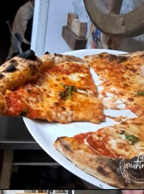 A wide slice of Neapolitan pizza served on a plate