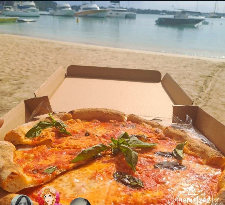 A La Marinara pizza in its box on the beach at Grand Baie (Mauritius)